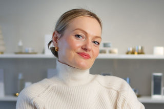 Skin Devotee Founder and Esthetician, Joanna Kula standing inside Skin Devotee Facial Studio with blurred retail background 