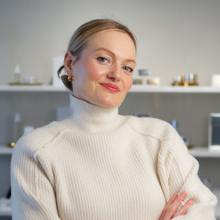 Skin Devotee Founder and Esthetician, Joanna Kula standing inside Skin Devotee Facial Studio with blurred retail background 