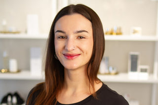 Philly Esthetician, Mia standing inside Skin Devotee Facial Studio with blurred retail background