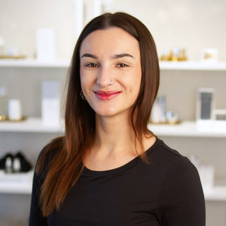 Philly Esthetician, Mia standing inside Skin Devotee Facial Studio with blurred retail background. 
