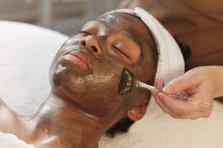 Young Black GenZ woman looking relaxed while receiving a masking treatment at Skin Devotee Facial Studio in Philadelphia