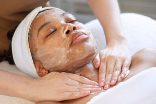 Young GenZ woman receiving a facial treatment with hands applying product to face at Skin Devotee Facial Studio in Philadelphia