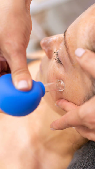 Person receiving a lymphatic boost facial massage with a cupping tool at Skin Devotee Facial Studio in Philadelphia